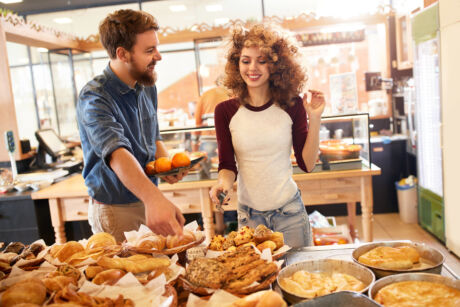 Young salesgirl service male customer